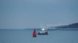 Lobster Fishermen Hauling Traps Off Boston In Early Morning Light With Island Shore In Background