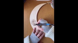 Artist burns captivating floral imprints on a moon-shaped wood piece