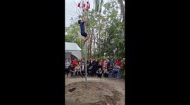 Vietnamese locals take turns to scale pole covered in oil in hope of winning prizes