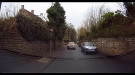 Dangerous driving UK car swerves onto the wrong side of the road. Scary near miss accident.