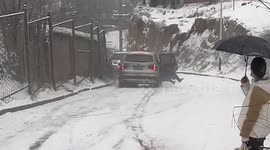 Motorists leap out of car sliding down snow-covered slope in China