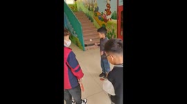 A five-year-old boy with the skill of balancing a ball on a racket makes teachers and friends admire