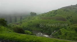 Train traveling waterfalls mounten green field beautiful nature in India Indian Railway