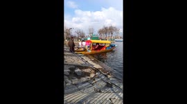 A VIEW OF DAL LAKE FROM NEHRU GARDEN LOCATED IN THE MIDDLE OF LAKE WITH SHIKARAS MOVING.