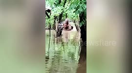Soldier carries flood-stricken resident through chest-deep floods in Indonesia