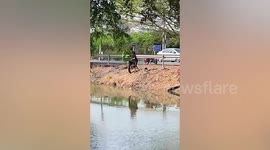 Two passing motorcycle riders rescue stray dog drowning in canal