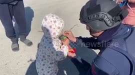Turkish coast guard gives fruit juice to toddler affected by earthquake in Hatay province