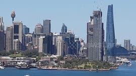 Unique video of SailGP AUSTRALIA super yacht sailing across Sydney harbour and panoramic city background .
