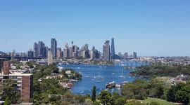 Unique video of SailGP USA super yacht sailing across Sydney harbour and panoramic city background .