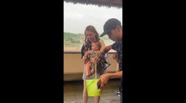 Cute baby girl is delighted to feed giraffe at Safari World, Bangkok