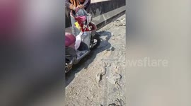 Motorcycle rider slips on mud left on road by construction truck