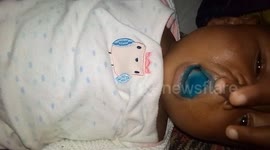 5 year old boy feeds 5 month old sister a blue lollipop while mom is getting some porridge
