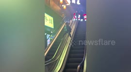Terrified woman shouts at children sliding down escalator handrails in China
