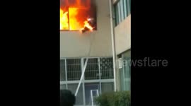 Firefighter escapes by jumping off building after his suit catches fire