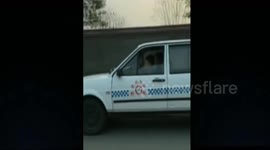 Kid drives coach car while adult plays mobile beside