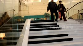 People play piano by walking down the stairs at a Tube station