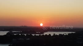 Sunset sinking orange circle over horizon - Sydney Australia