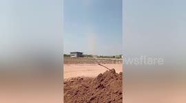 Dust devil tornado tears through wasteland on hot day in Thailand