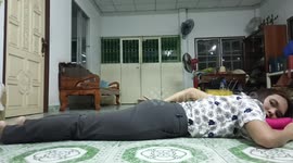 Playful pet cat helpfully massages her owner's bottom