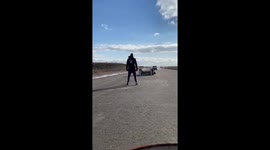 A car performs a long jump, and a guy is under it
