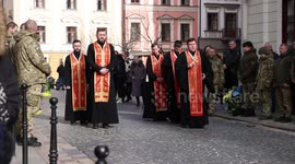 Clergy stand with Ukrainian military personnel on Lviv street prior to funeral for fallen servicemen