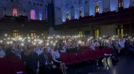 Ukrainian diaspora sing and wave phones with flashlight on in Sydney, Australia