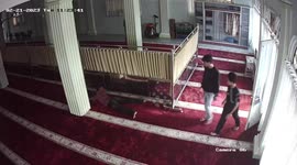 A thief pretended to be asleep when he was caught by guards after he was caught on a security camera stealing money from charity at a place of worship in Indonesia