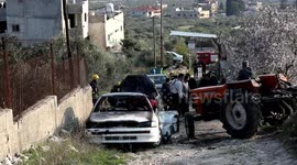Palestinians inspect car set on fire by Jewish settlers in Nablus