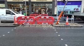 London's Kensington High Street crash: Cordoned off island,  bent traffic lights and flower tribute