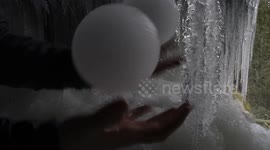 Perfectly-sphered ice balls naturally form below frozen waterfall in Canada