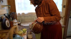 Woman looks like she's walked straight out the 1940s with vintage home where she cooks wartime food