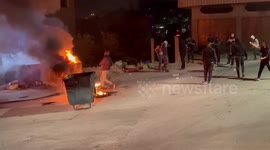 Palestinian protesters burn tires and hurl stones towards Israeli forces during clashes