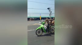 Motorcycle rider cruises with his feet on handlebars