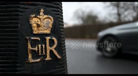 Traffic driving through Regents Parks and the Queens logo, London, United Kingdom