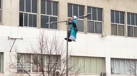 Maiden-dressed guy climbs and amuse himself on a lamp post during street festival - Party above all