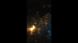 Fire explosion of gas main in front of house, neighbors frantically rushing to put it out incorrectlywith water hoses and are in possible danger!