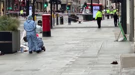 Forensic officers work at the scene of a stabbing on Oxford Street in Central London
