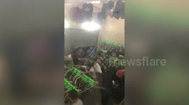 Frenzied bargain-chasers shove each other and clamber on racks at used clothes shop