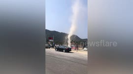 Woman in shock as dust devil sweeps through car park in southern China