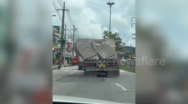 Pile of construction hollow blocks collapses on truck and falls onto road