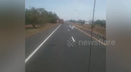 Large pile of haystacks fall from back of moving truck