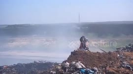 Palestinian members of Civil defense firefighters effort to control a fire that broke out at the main waste in Johr Al-Deek