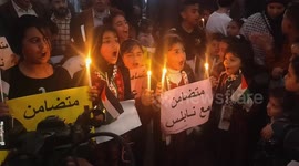 Palestinians light candles during a rally in solidarity with West Bank people