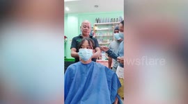 Emotional teenager with cancer cries while her head is shaved as hairdressers cheer her up