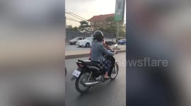 Girl struggles to hold onto mum while riding motorcycle
