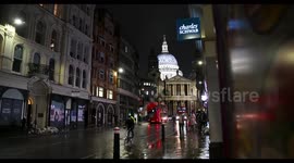 Buses driving past St Paul's Cathedral and Charles Schwab, London, United Kingdom