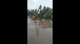 The woman operating the excavator on the ferry moving on the river professionally