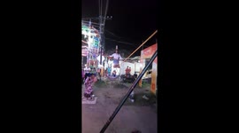 A little Indian girl is performing with a plate while walking across a tight rope on two poles in Druga puja sambalpur