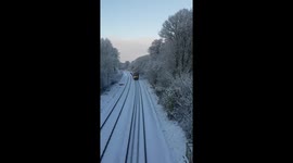 Harrogate to Leeds train in passing by snowy cookridge.