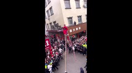 Bedazzling artisans on stilts tower above crowds during Chinese New Year parade